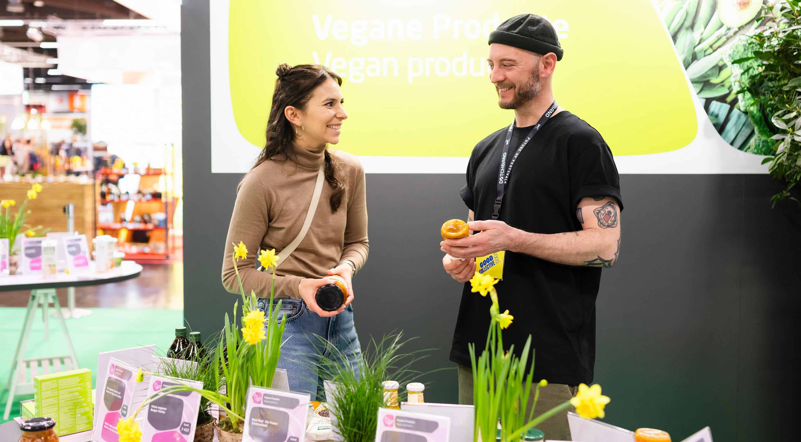 Nora und Julian vom Good Food Collective sehen sich Produkte auf der Sonderfläche Planetary Health an.