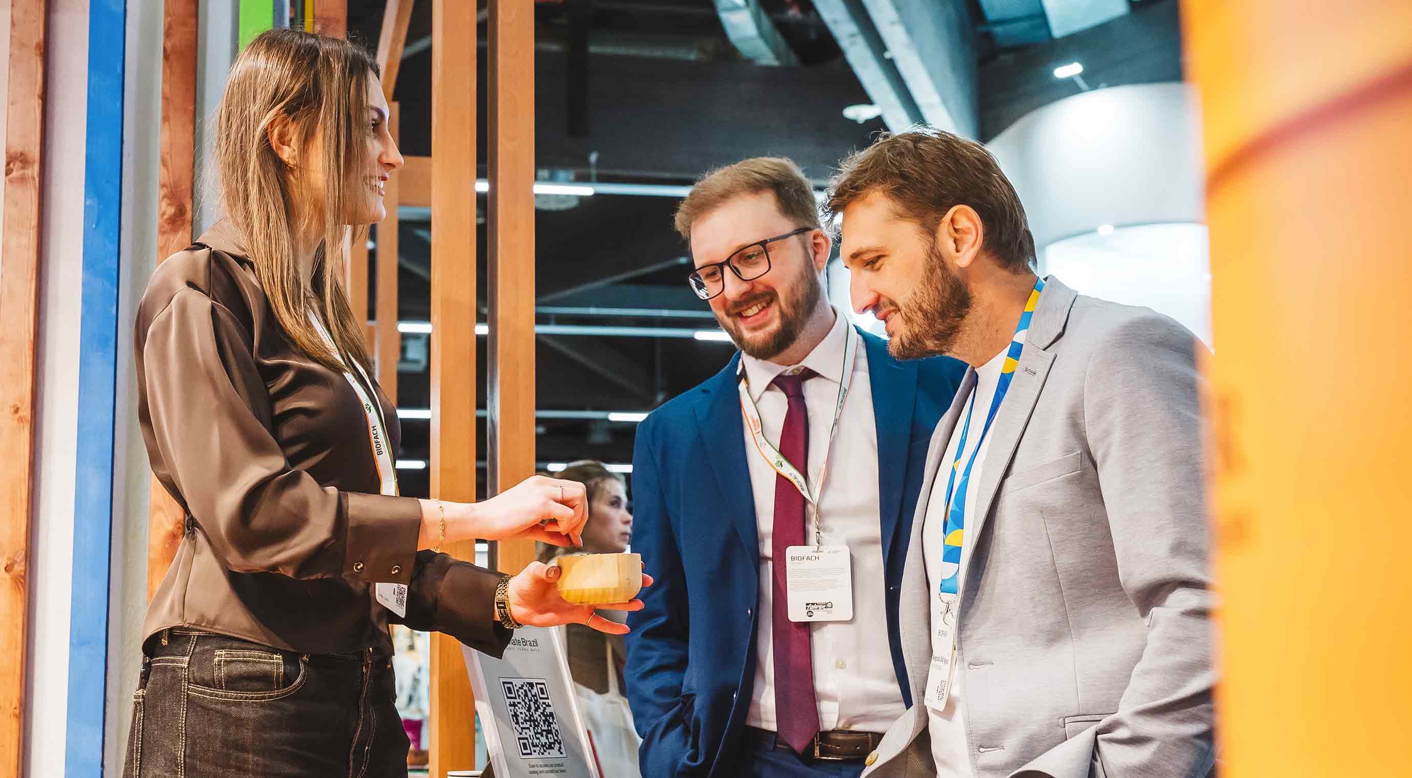 Zwei Besuchende am Stand einer Ausstellerin bei der Produktverkostung